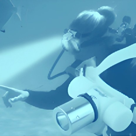 se muesta a una persoan buceando con una lampara de cabeza